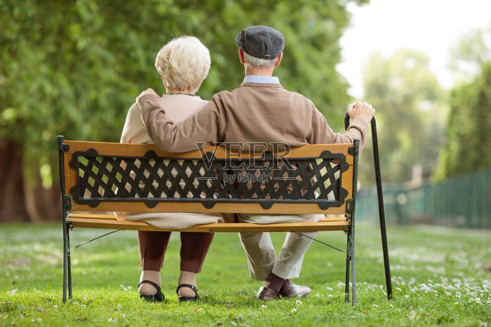 一对老年夫妇坐在公园的木凳上照片摄影图片
