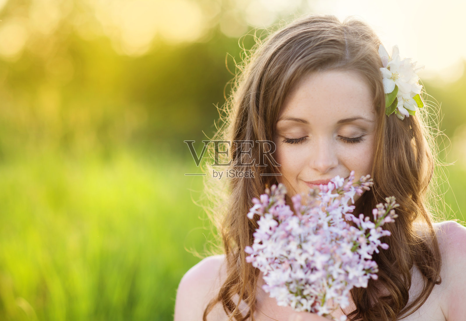 美丽的春姑娘在草地上开着花照片摄影图片