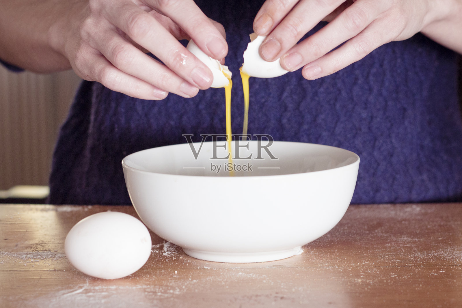 蛋黄掉进碗里。照片摄影图片