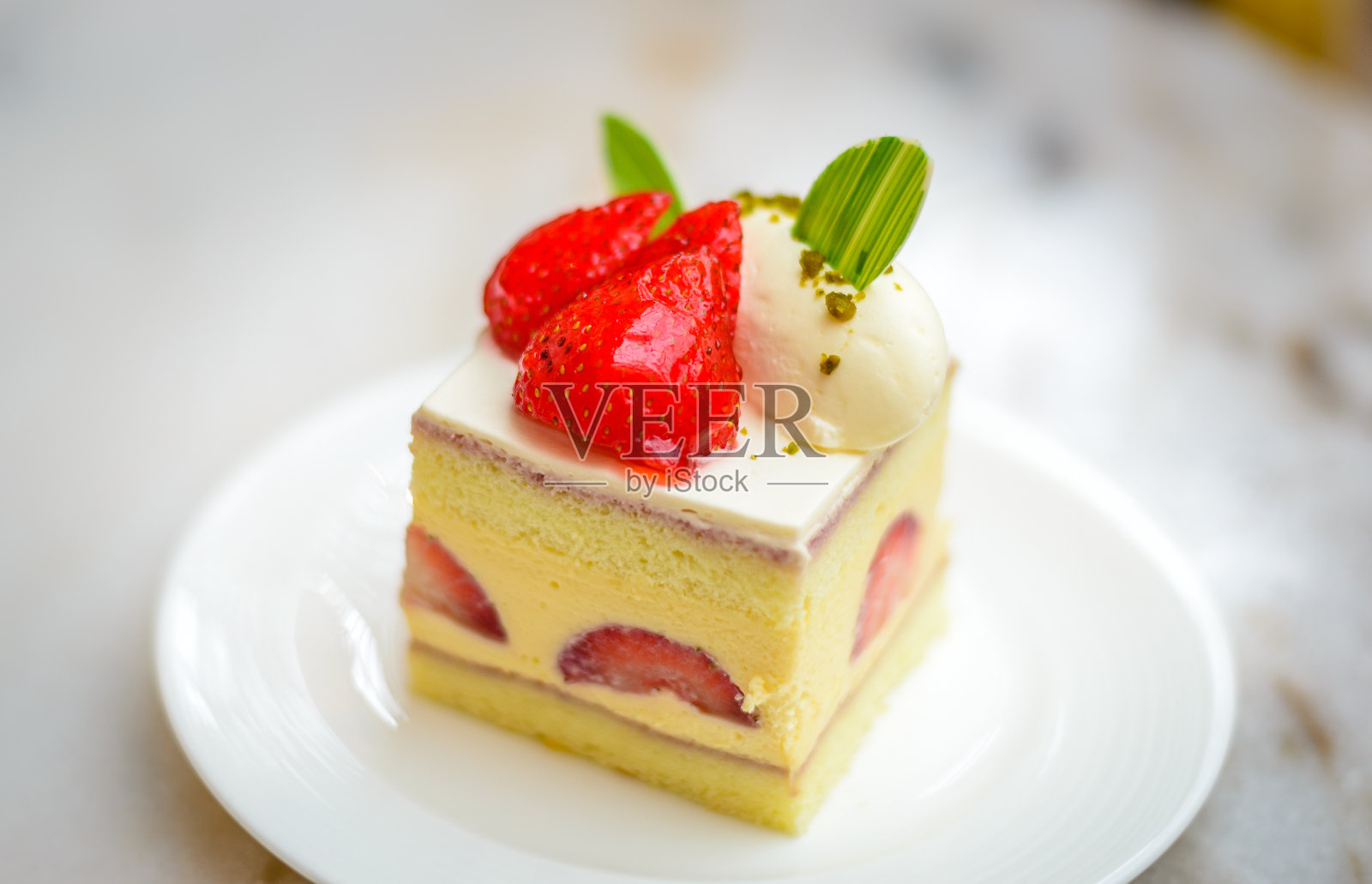 白色瓷盘上的草莓雪纺Entremet蛋糕照片摄影图片
