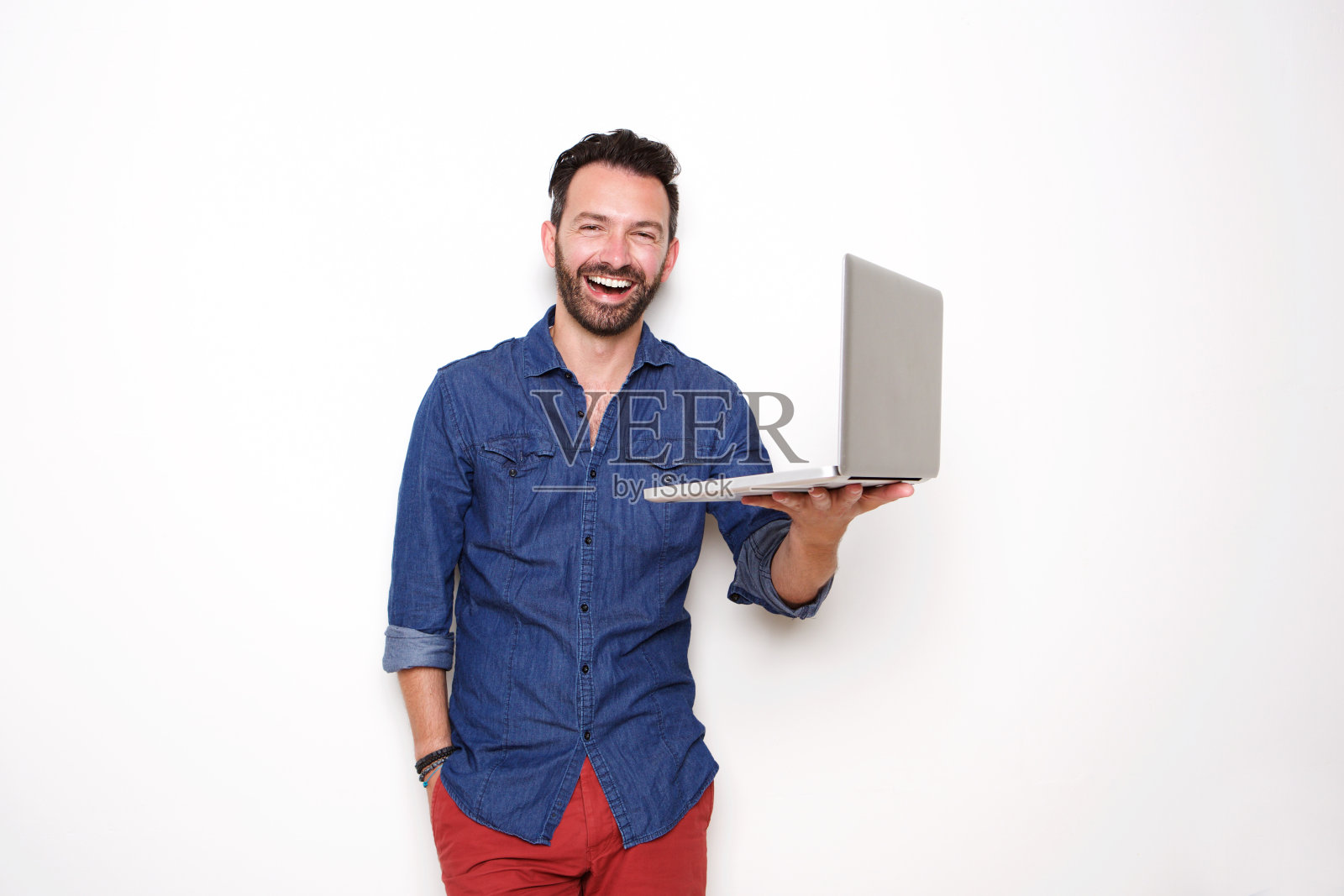 微笑的成熟的家伙拿着笔记本电脑照片摄影图片