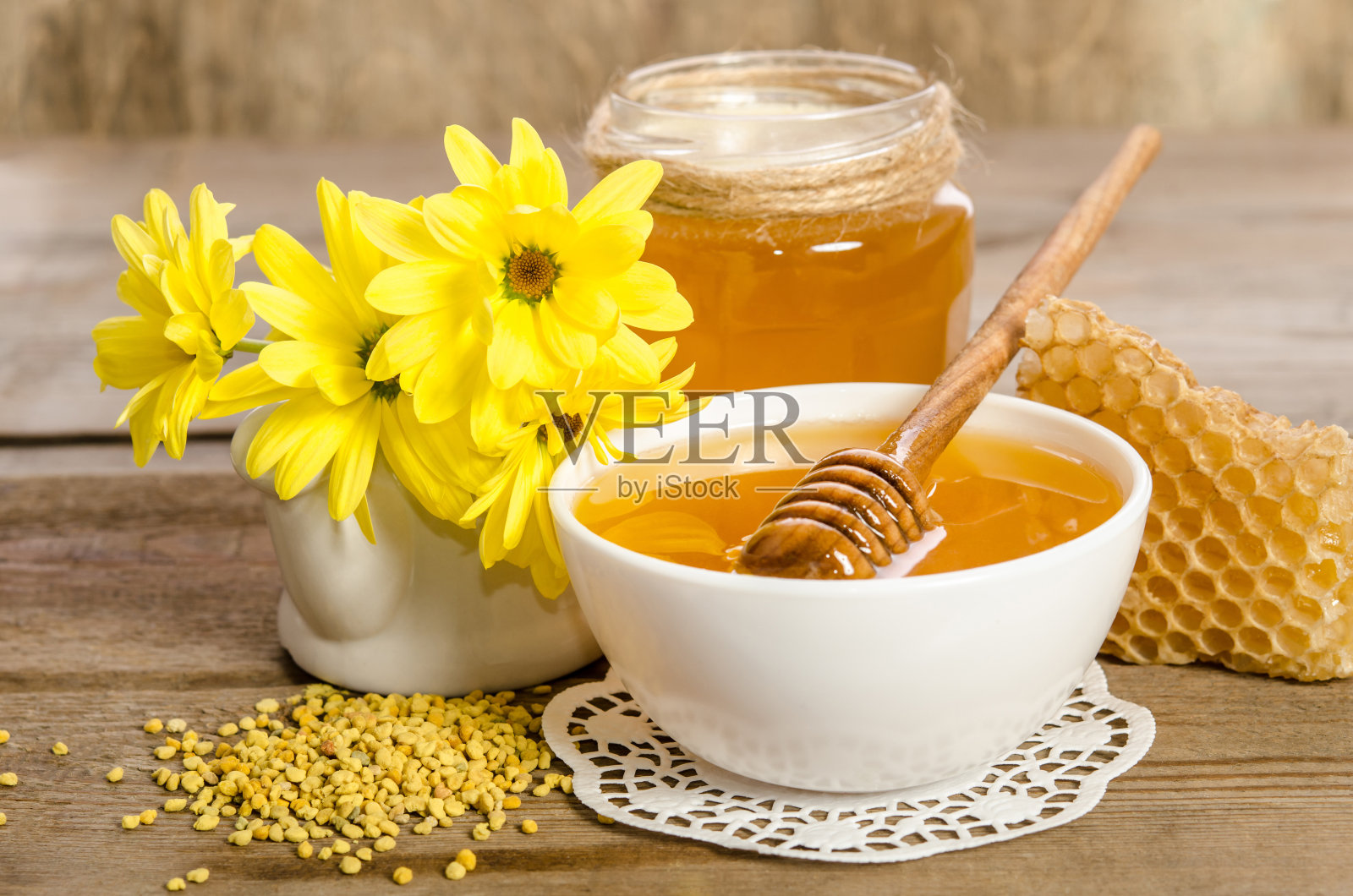 木质背景上的黄色花朵和蜂产品(蜂蜜，花粉，蜂巢)照片摄影图片