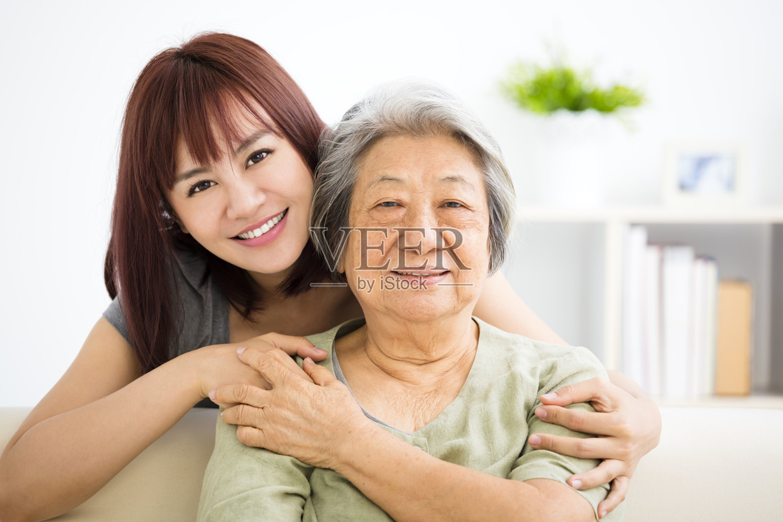 祖母和孙女。年轻的女人细心地照顾年老的女人照片摄影图片