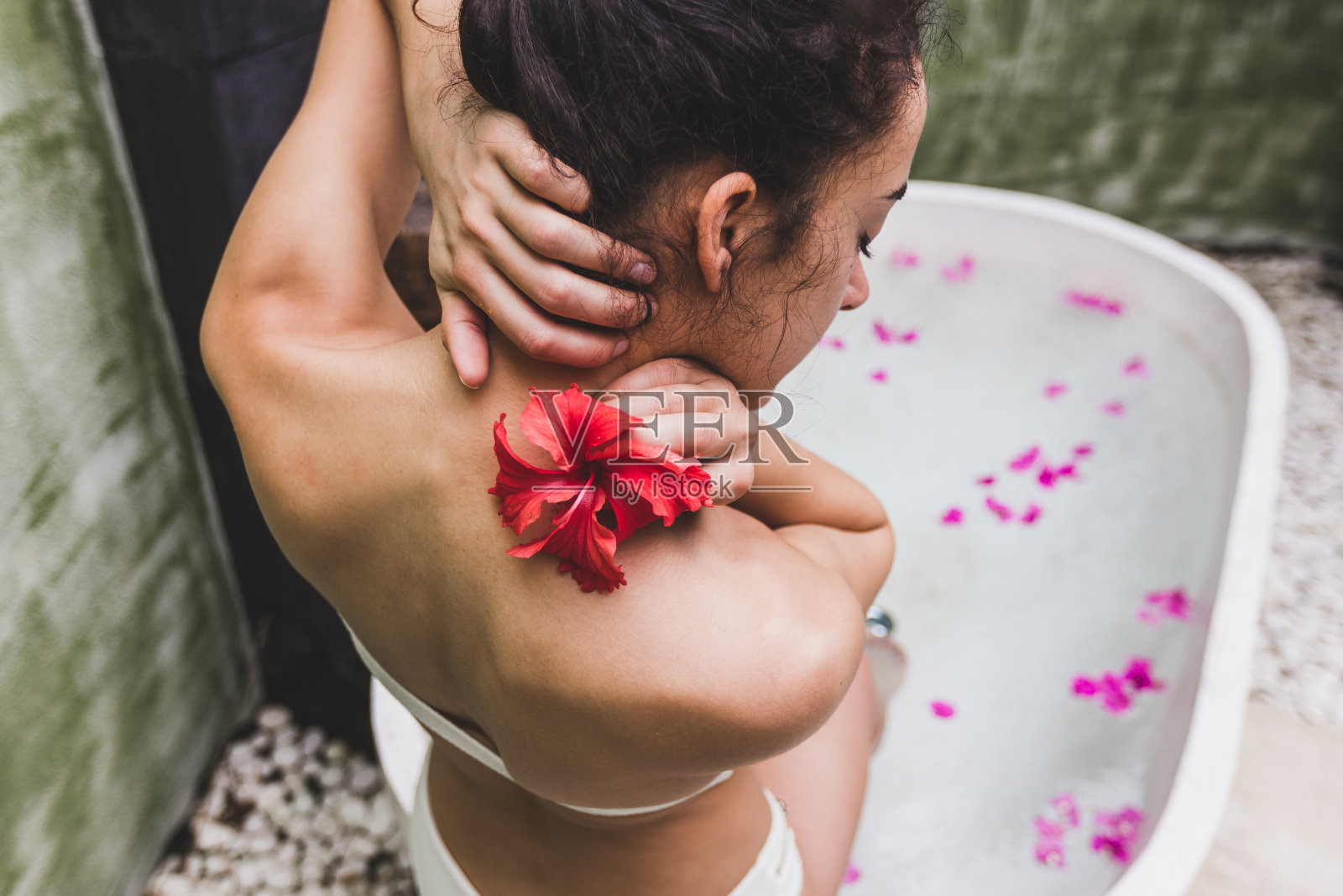 女人放松在圆形户外沐浴热带鲜花，有机皮肤护理，豪华水疗酒店，生活方式照片照片摄影图片