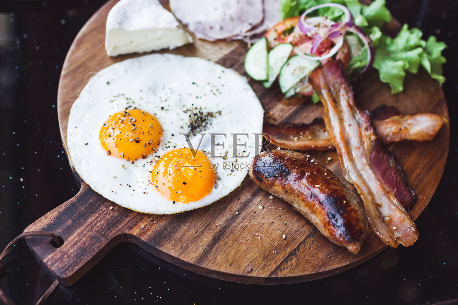 早餐有煎蛋，培根和奶酪卡芒贝尔在木板上照片摄影图片