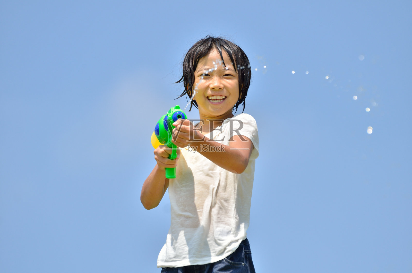 女孩玩水枪(蓝天)照片摄影图片