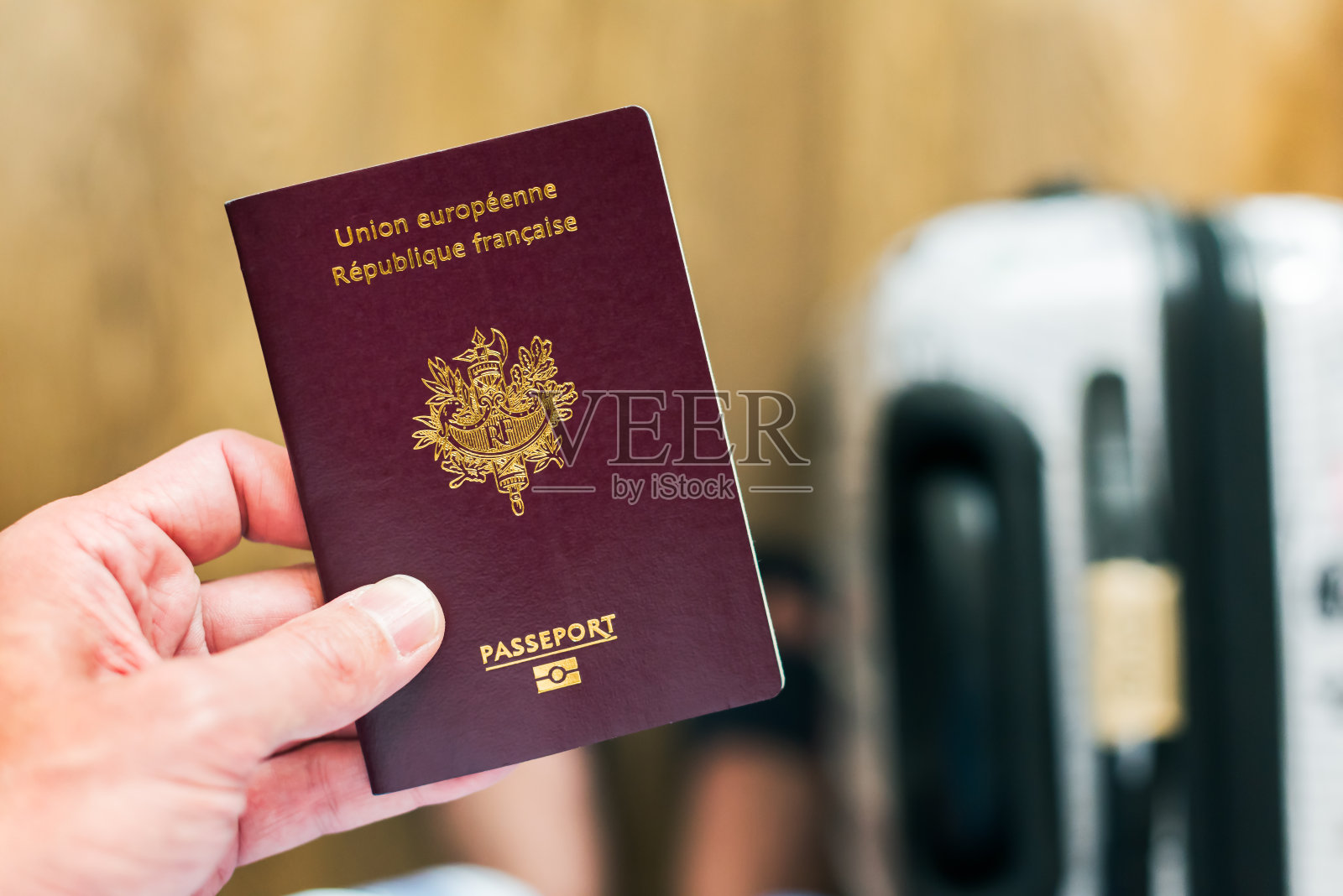 手里拿着一本法国-欧洲护照，行李在英国机场照片摄影图片