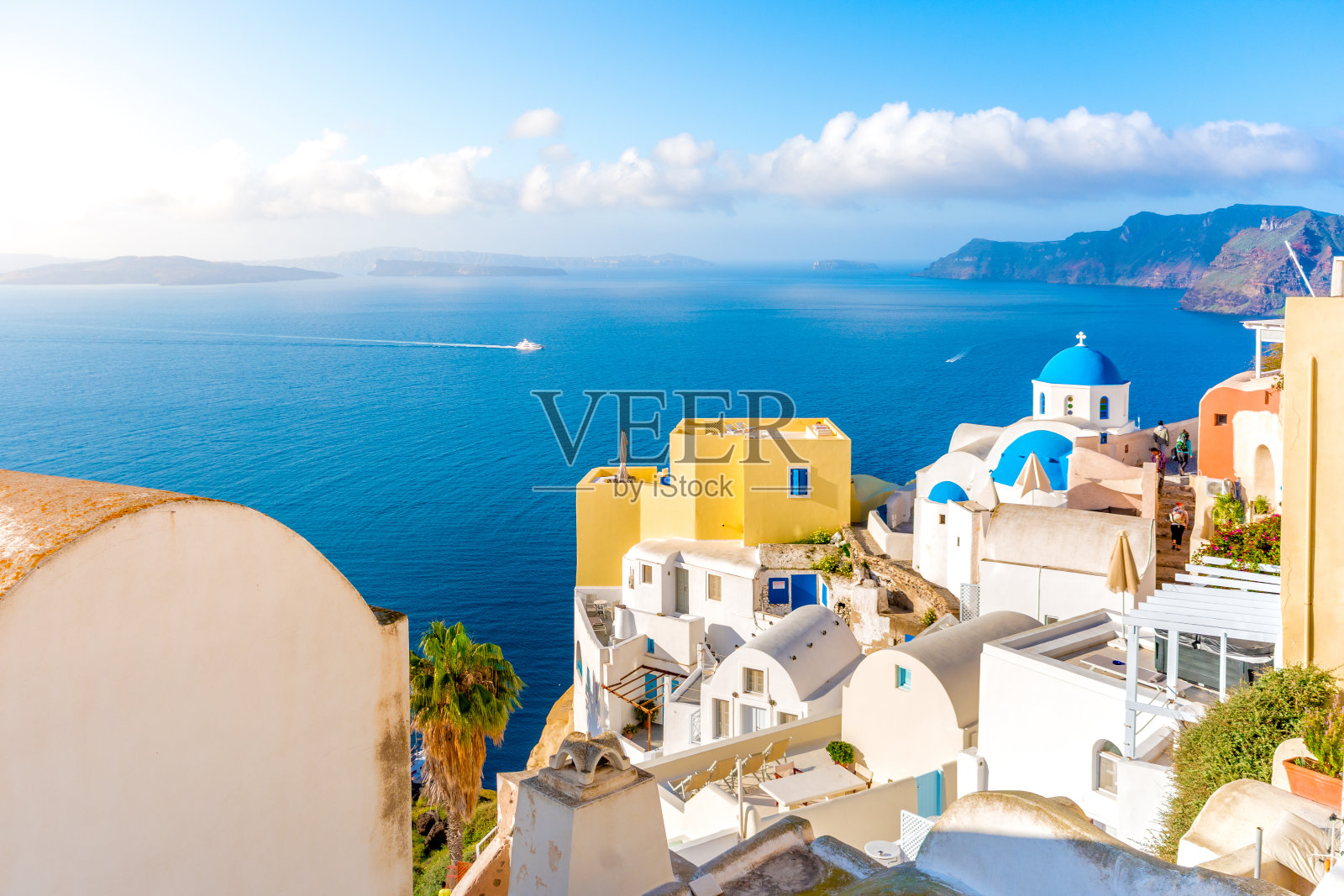 希腊圣托里尼岛的伊亚镇。位于爱琴海火山口的传统和著名的蓝色圆顶房屋和教堂照片摄影图片