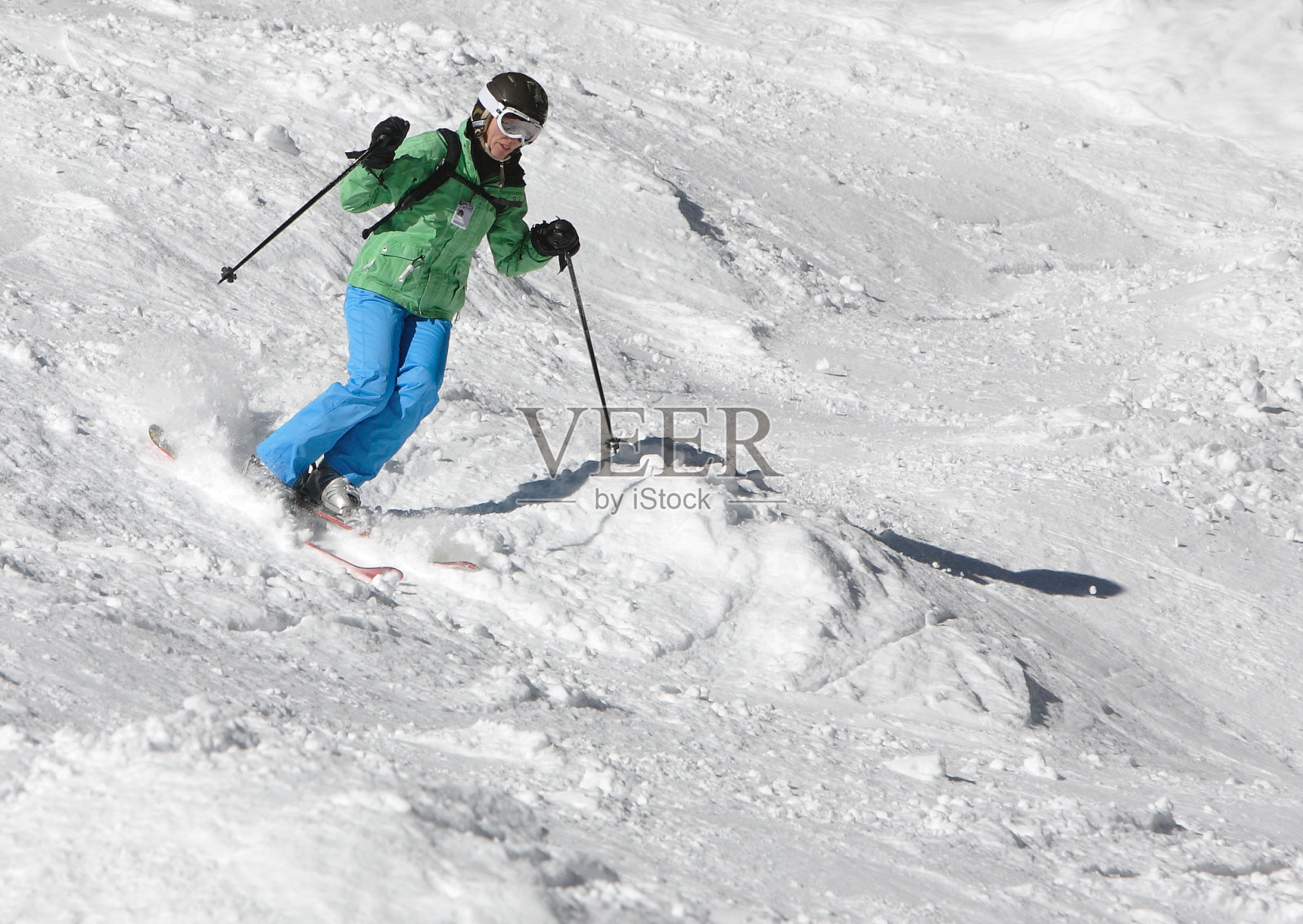 穿着绿色和蓝色的女子滑雪者照片摄影图片