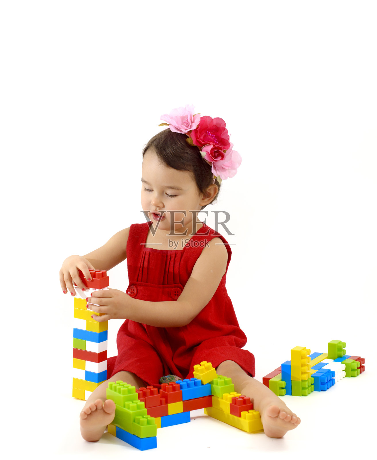 有趣的小女孩玩建筑设置在白色的背景照片摄影图片