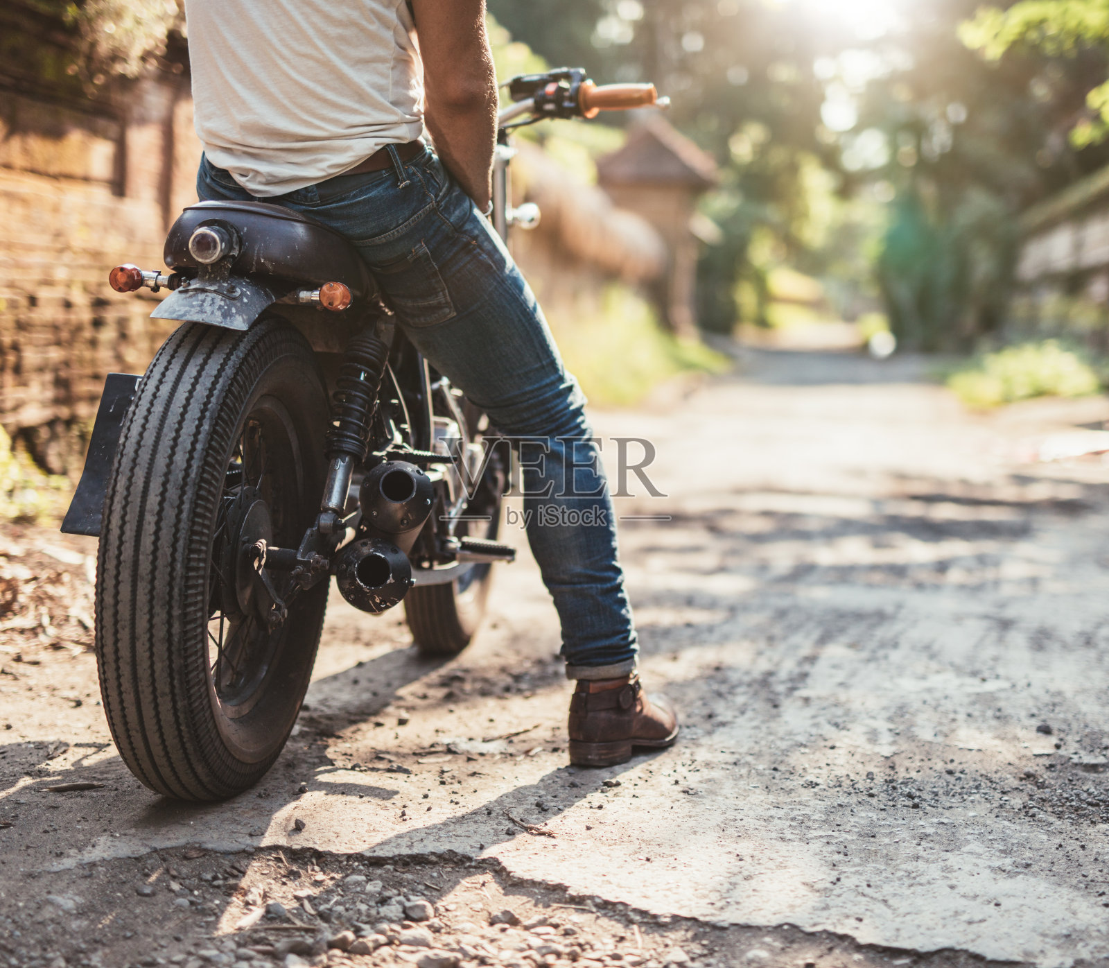 一个年轻人骑着摩托车在泥土路上照片摄影图片