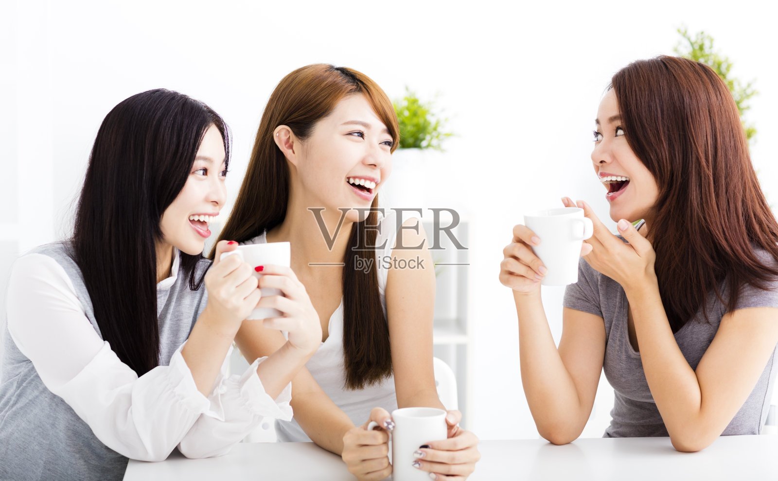 三个快乐的年轻女子在客厅聊天照片摄影图片