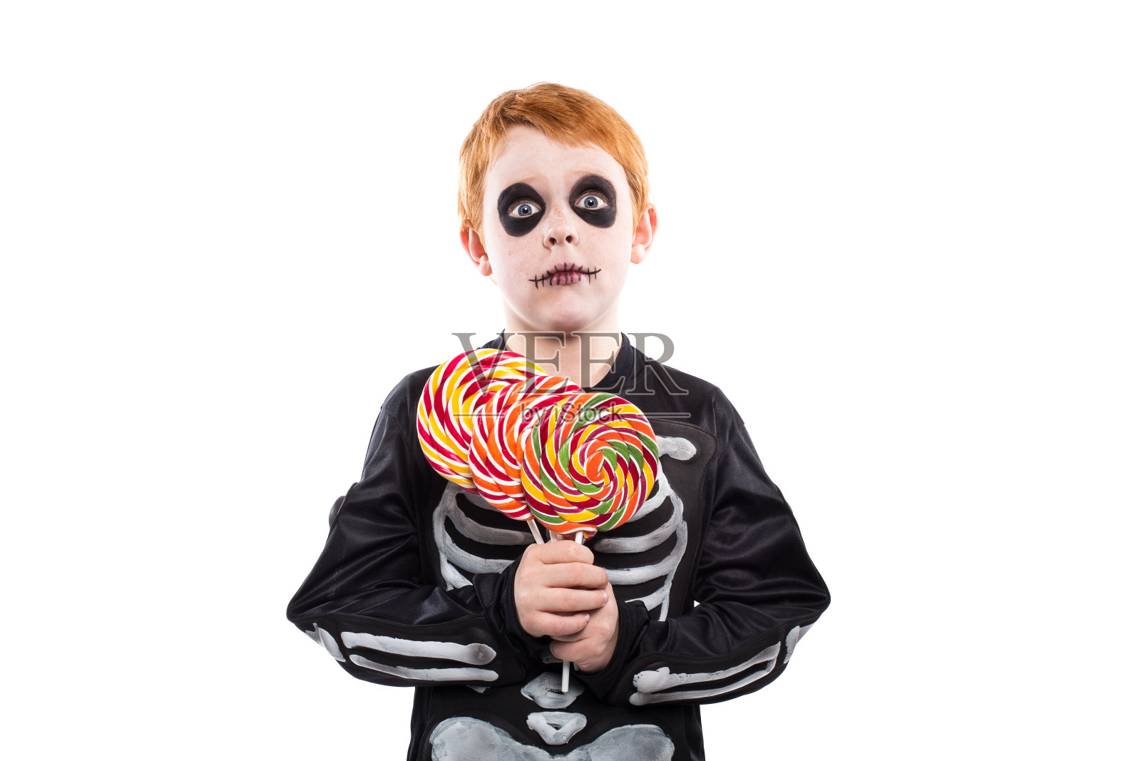 小男孩穿着万圣节服装，拿着五颜六色的糖果照片摄影图片