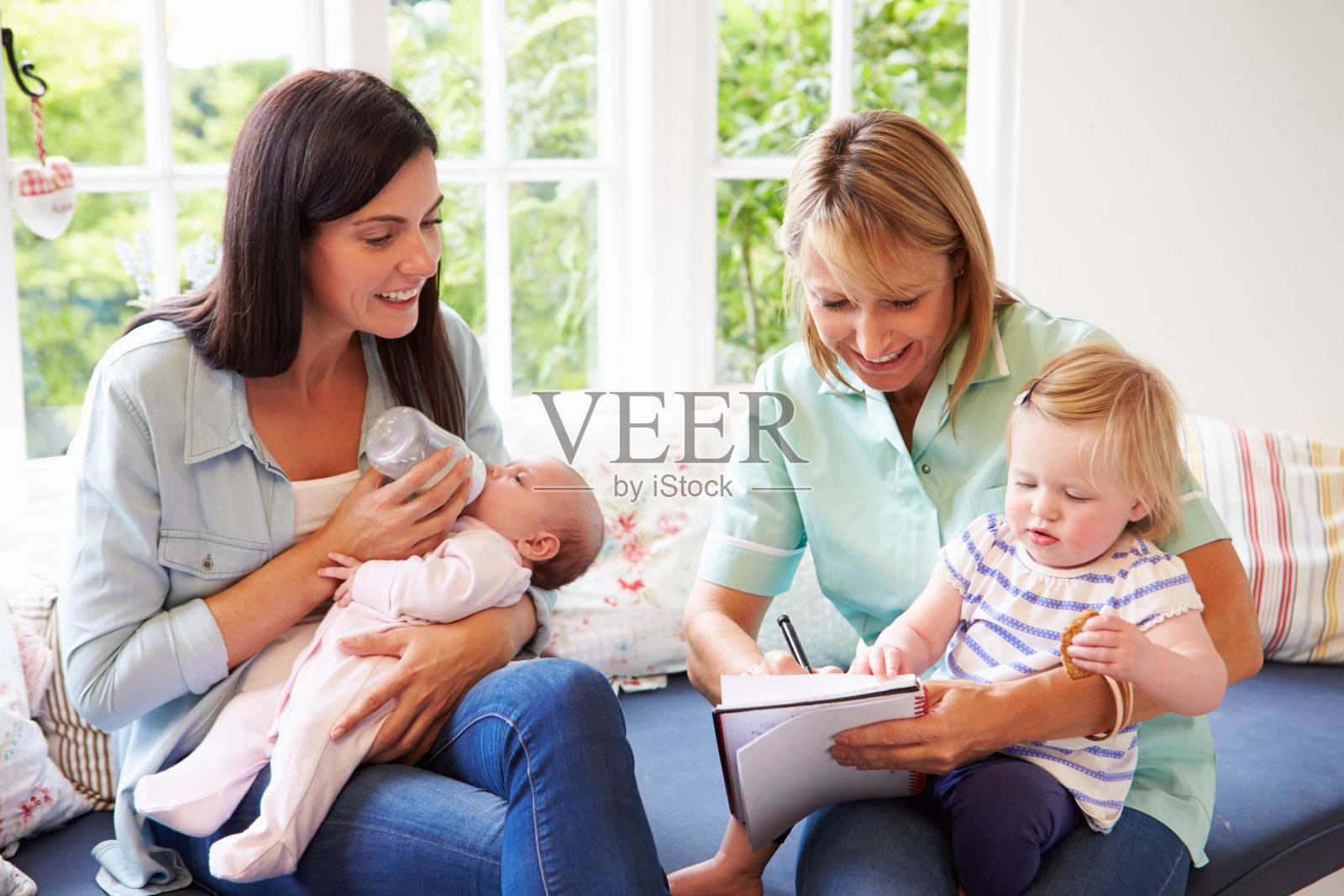 母亲与婴儿在家会见健康访客照片摄影图片