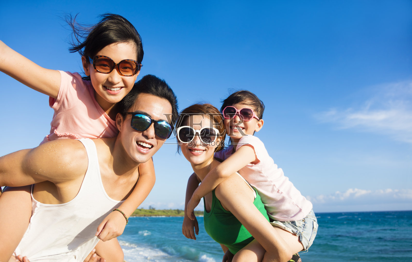 快乐的家庭在海滩上玩照片摄影图片