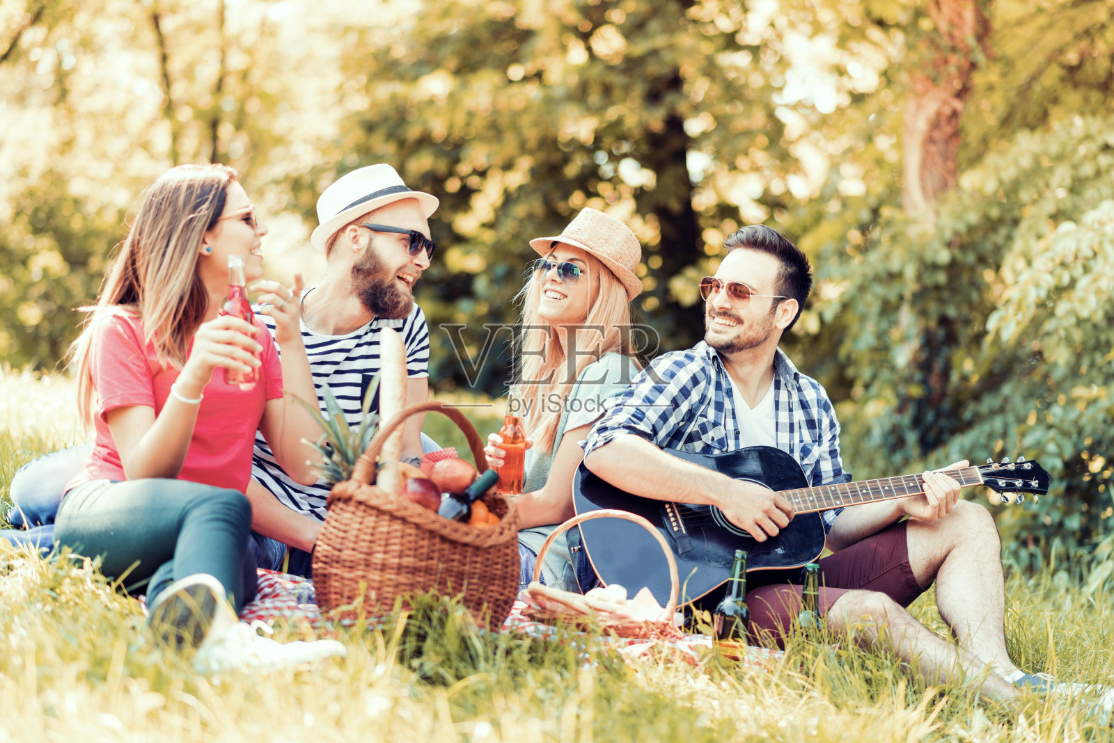 快乐的年轻朋友们在公园野餐。照片摄影图片