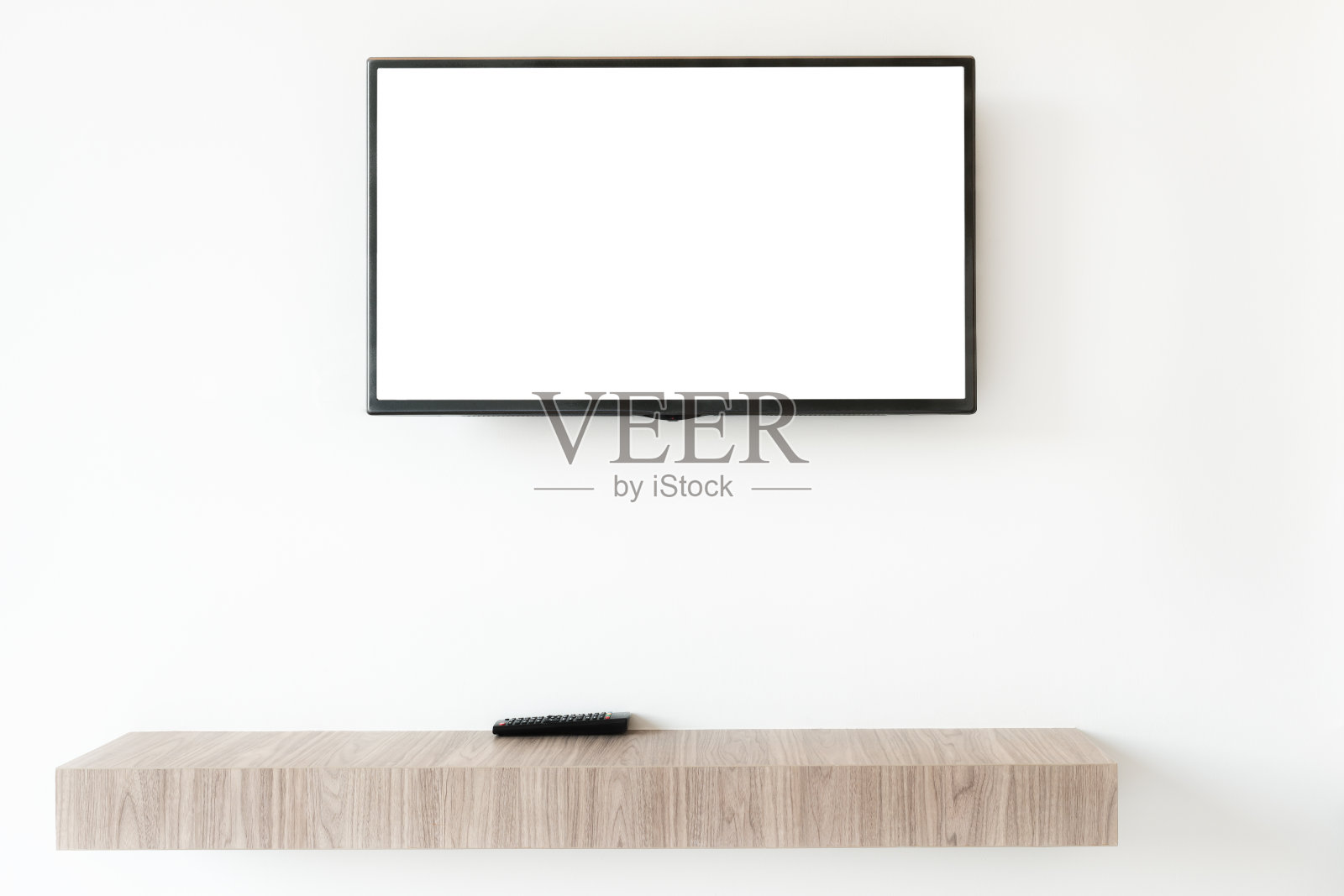 在家里客厅的木架上模拟平板电视屏幕和远程控制面板。照片摄影图片