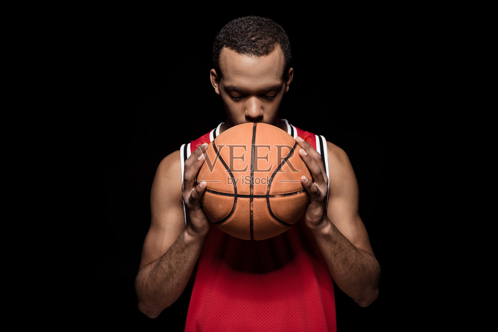 非裔美国篮球运动员与球在黑色的姿势照片摄影图片