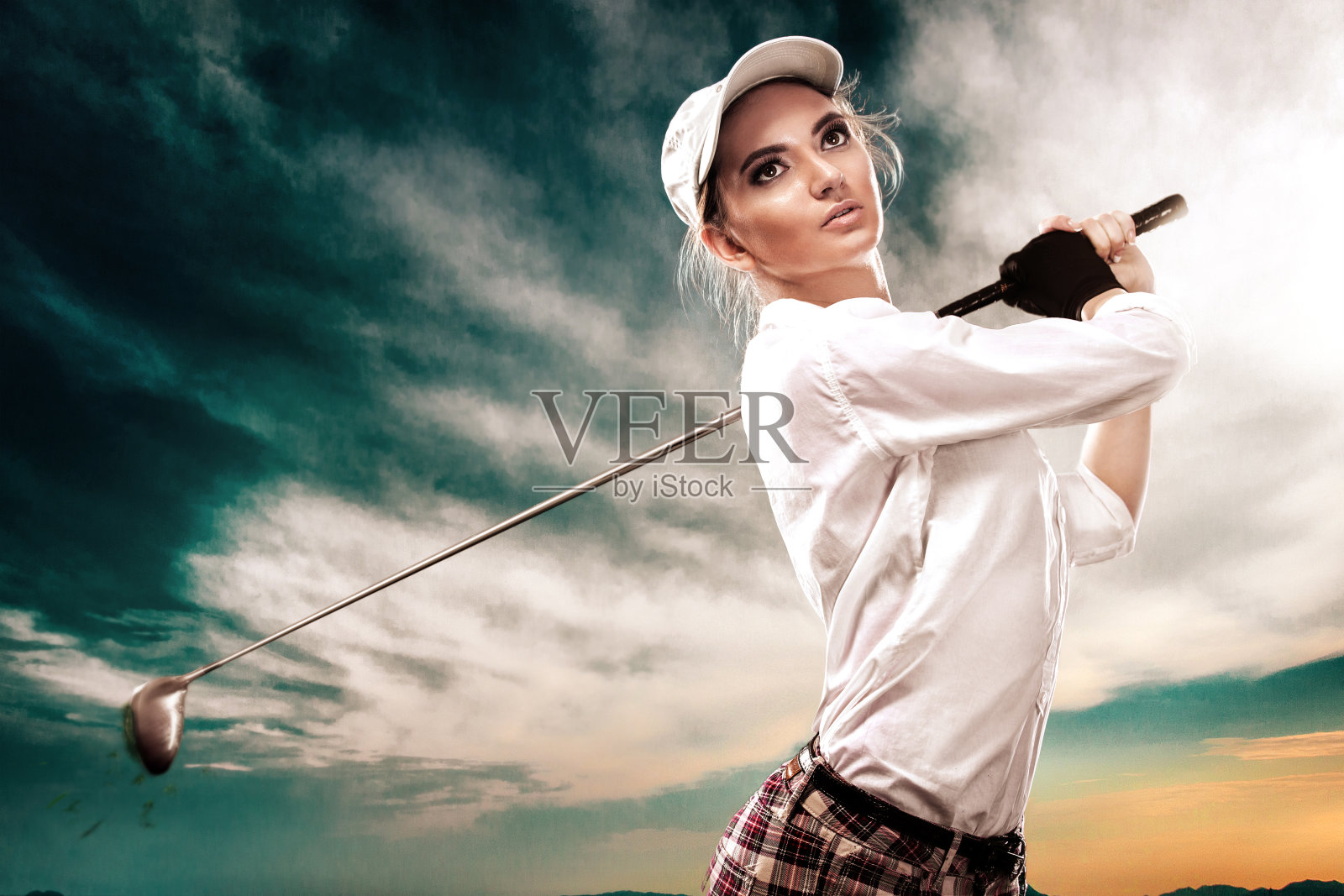 女子高尔夫球手击球的天空背景。副本的空间。广告的概念。照片摄影图片