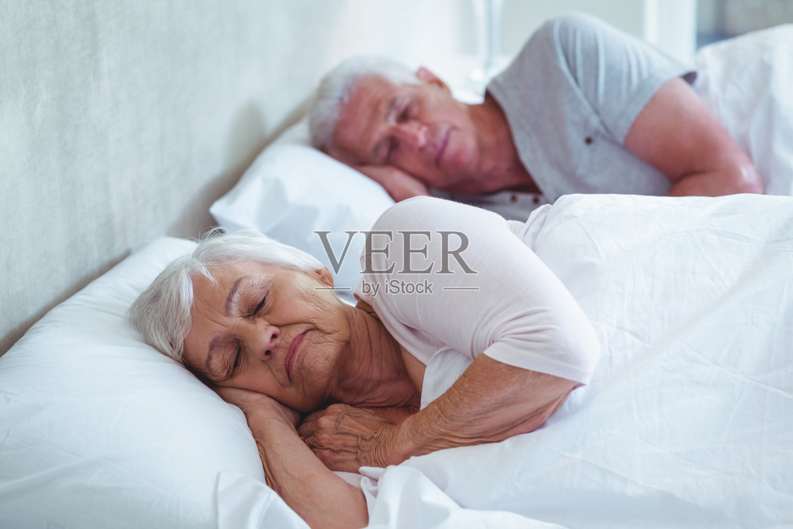一对老年夫妇睡在床上照片摄影图片