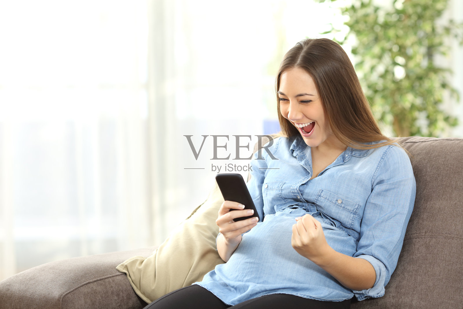 孕妇兴奋地看着手机照片摄影图片