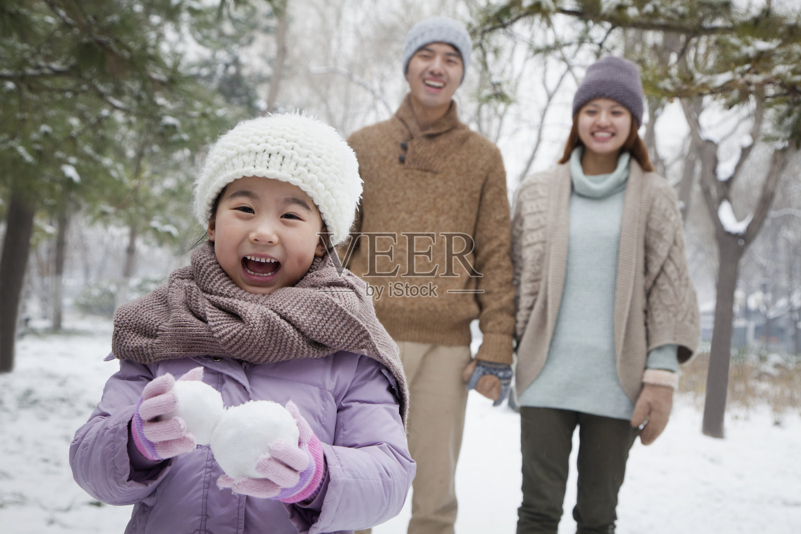 年轻的女孩在冬天拿着雪球照片摄影图片