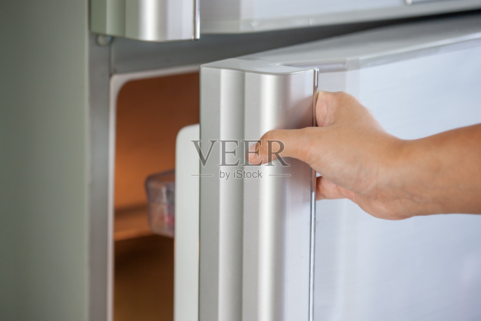 女人用手打开冰箱门照片摄影图片