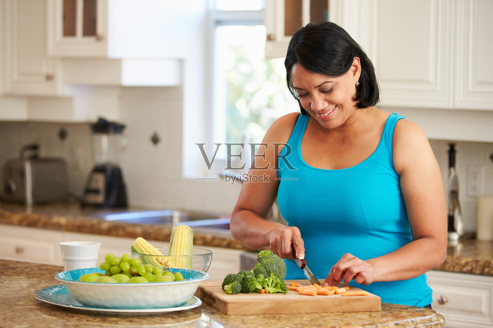 胖女人在厨房准备蔬菜照片摄影图片