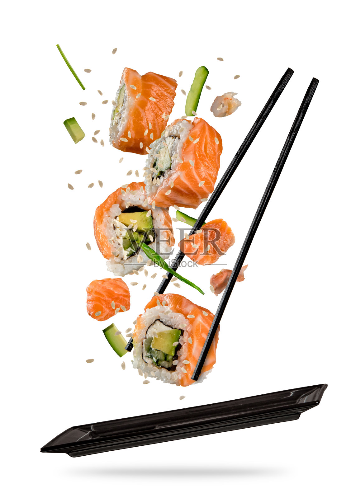 寿司放在筷子之间，放在白色的背景上照片摄影图片