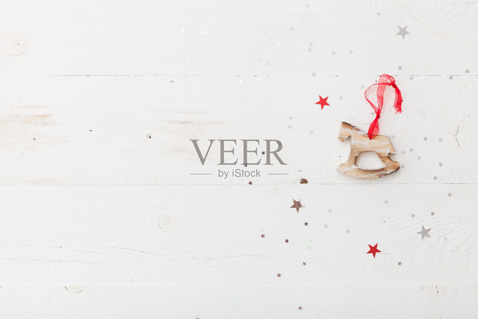 俯视图上的木马圣诞装饰在复古的木制背景与闪闪发光的星星。假日季节和庆祝概念。照片摄影图片