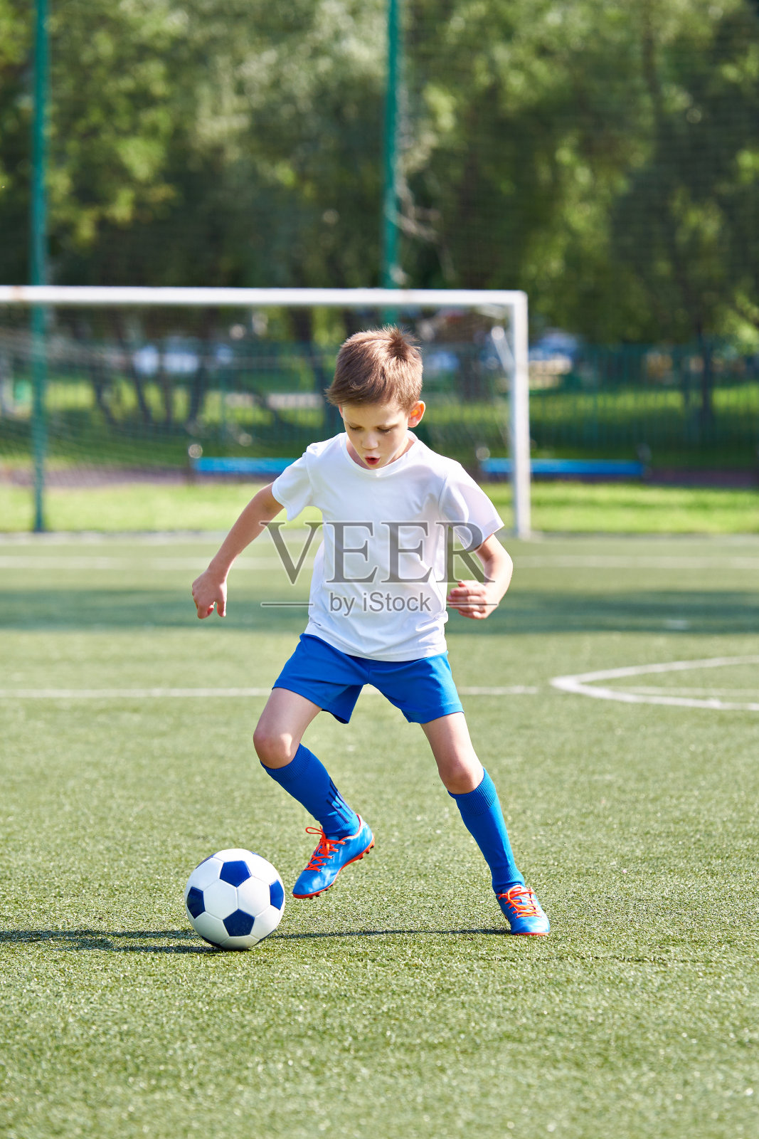 带着球跑的男孩足球运动员照片摄影图片