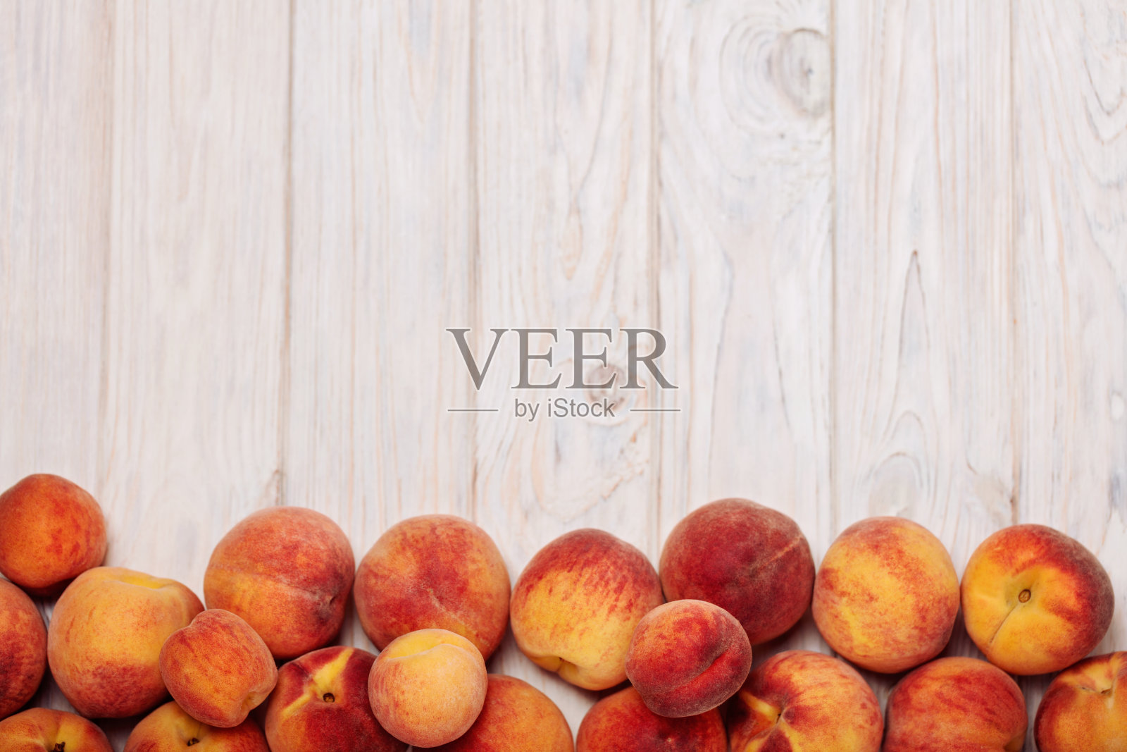 成熟美味的桃子在一个轻木制的背景。照片摄影图片
