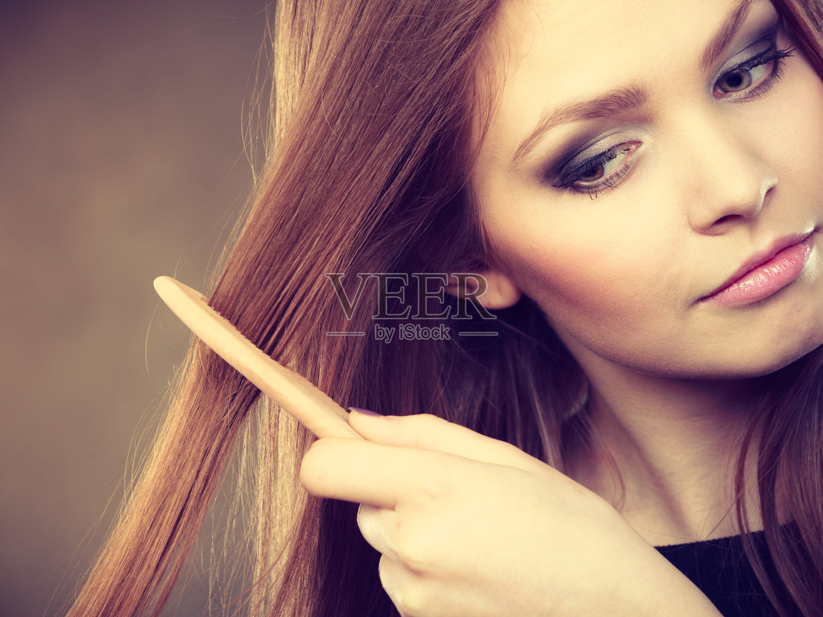 长发女子在梳头。照片摄影图片