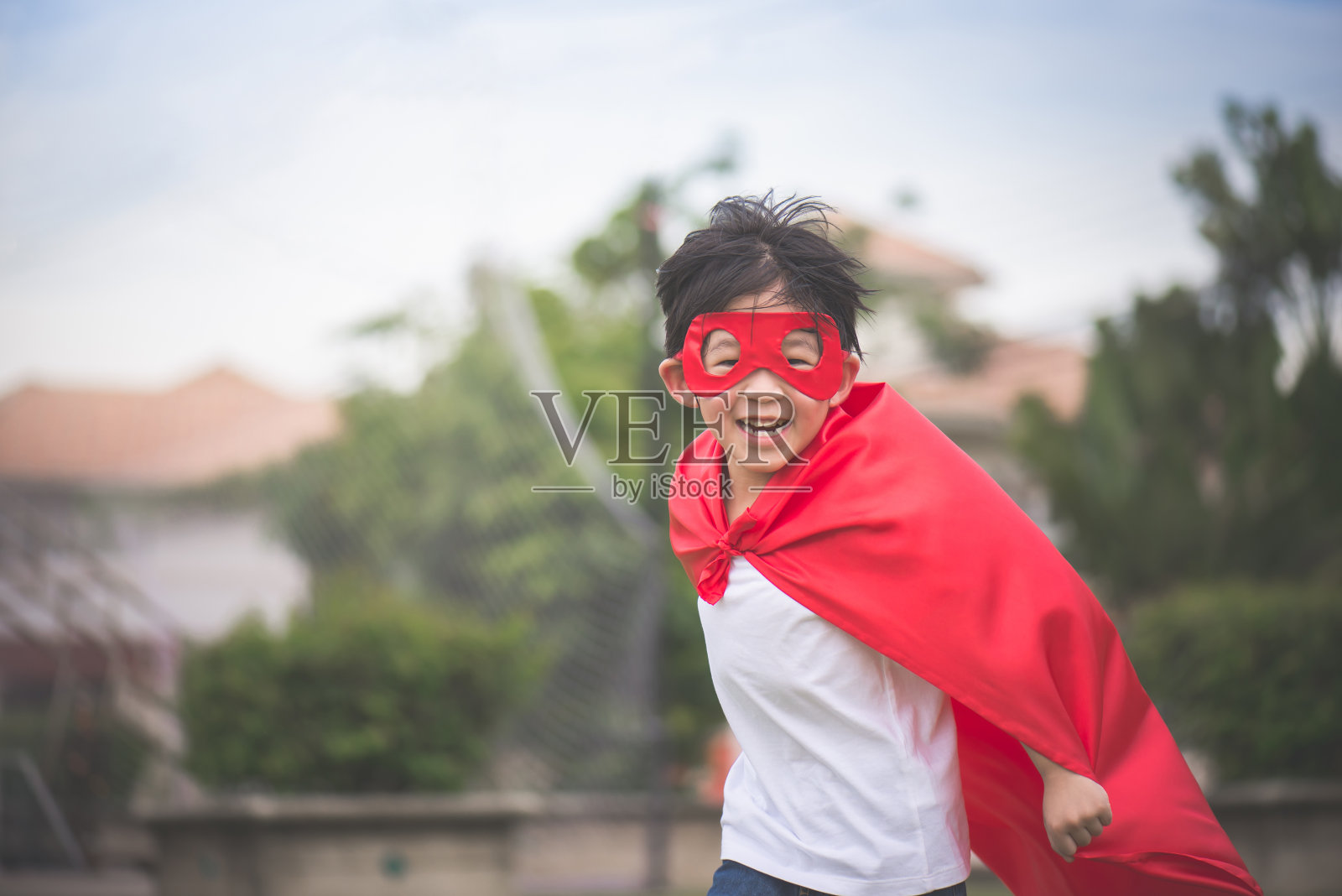 亚洲小孩穿着超级英雄的服装在公园里玩照片摄影图片