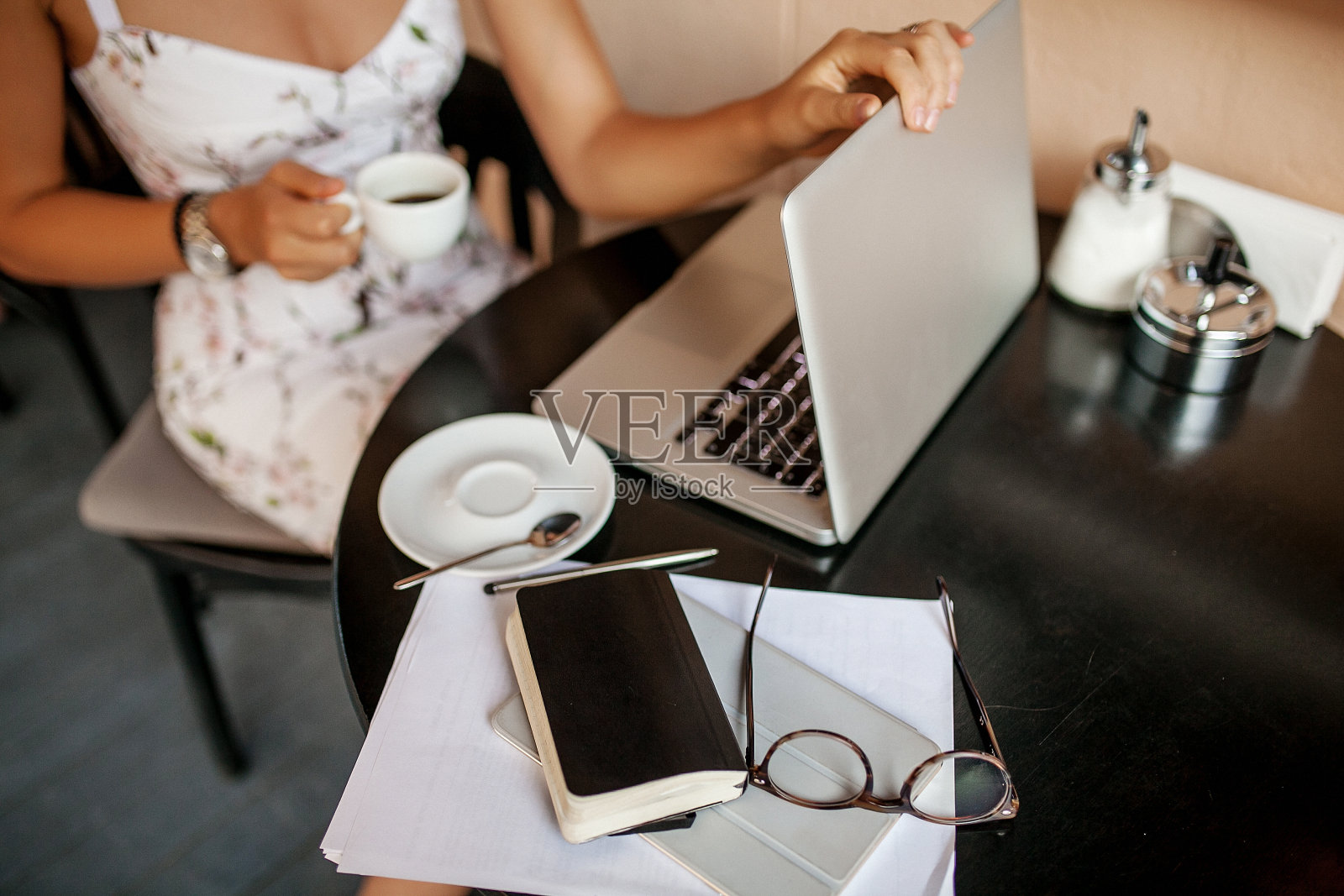 年轻的商业女性在咖啡馆用平板电脑和笔记本电脑照片摄影图片