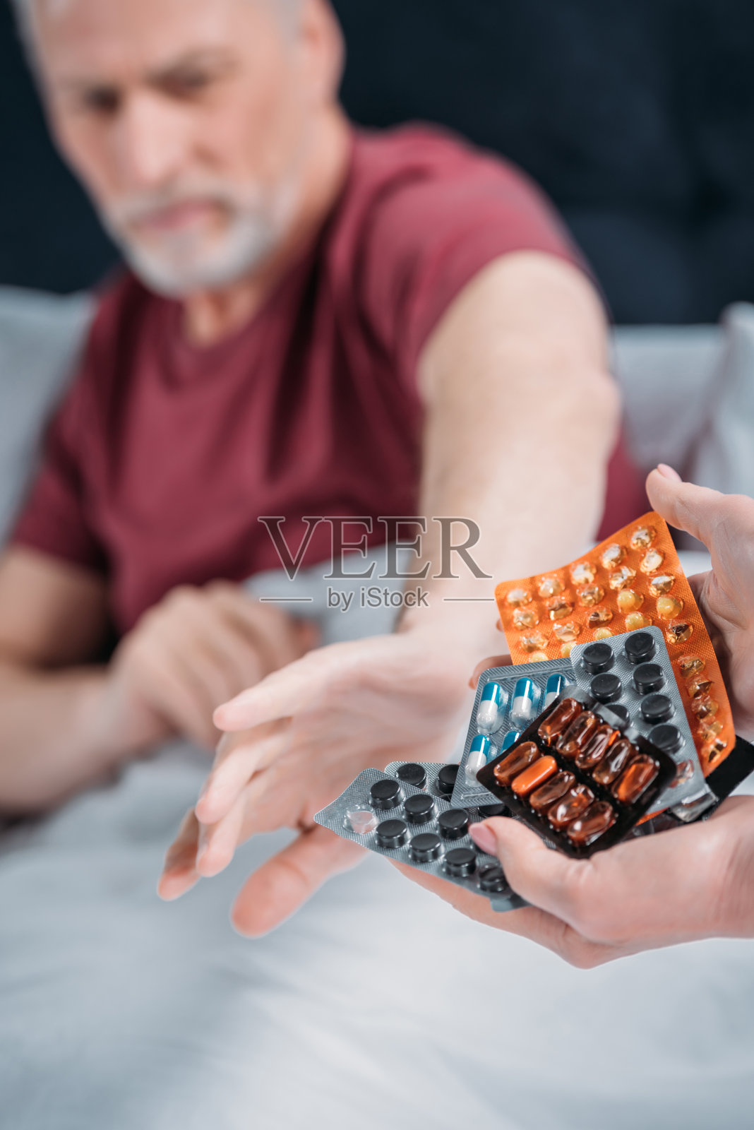 有选择地专注于女人手里拿着各种药，为生病的丈夫吃药照片摄影图片