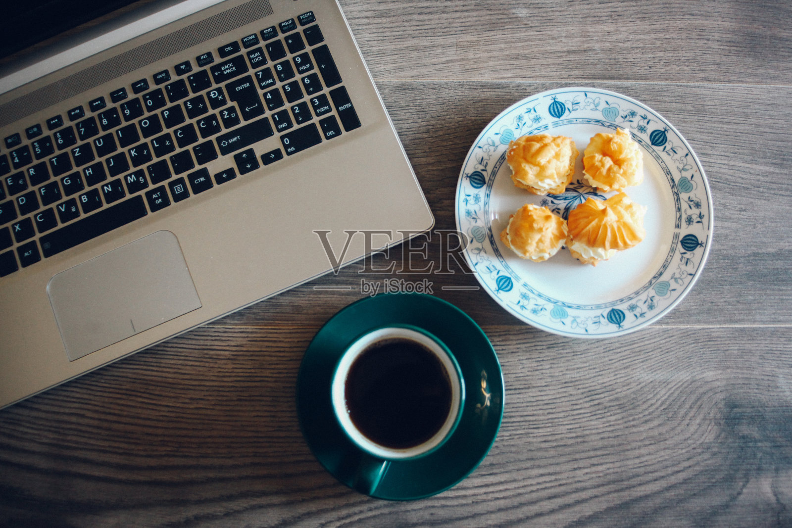 笔记本电脑，饼干和一杯咖啡放在木桌上照片摄影图片