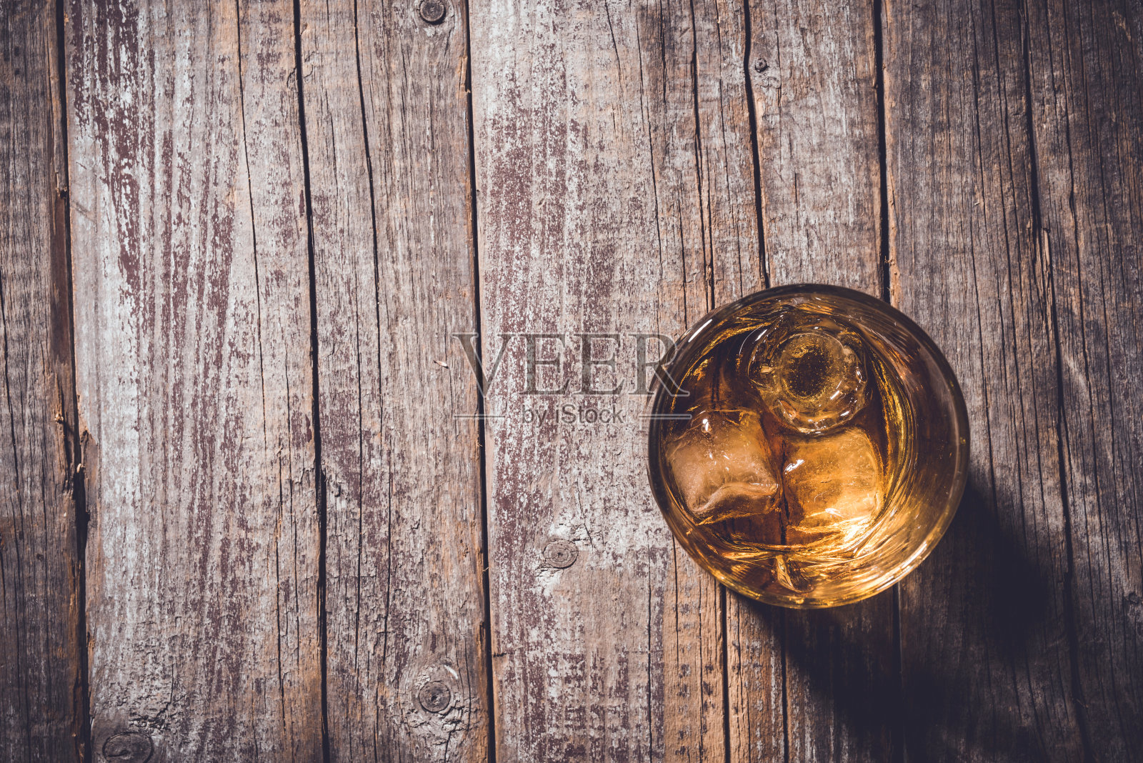 威士忌酒杯放在旧木桌上。照片摄影图片