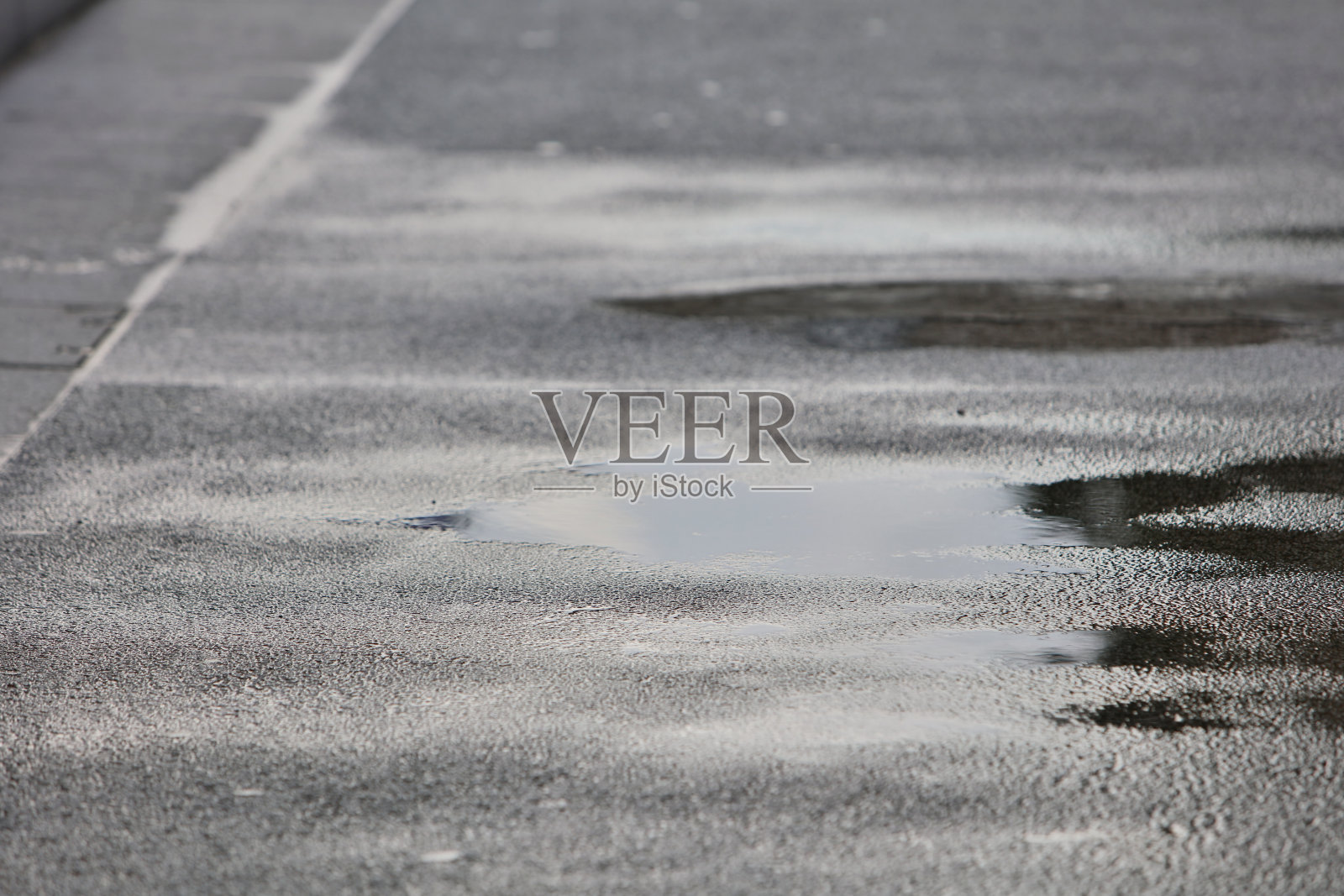 雨在城市的人行道上形成水坑照片摄影图片