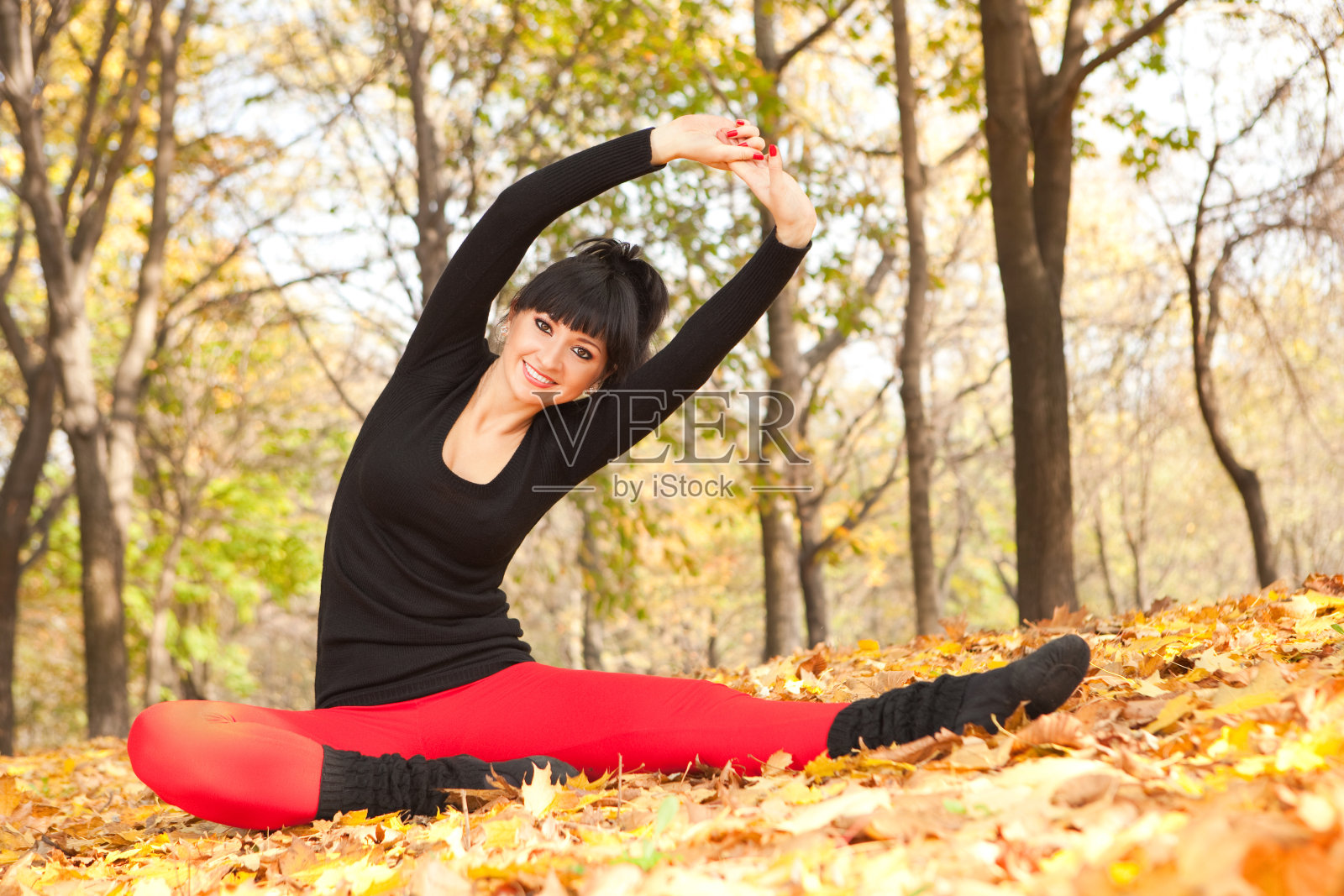 在秋天的公园里做瑜伽的漂亮女人照片摄影图片