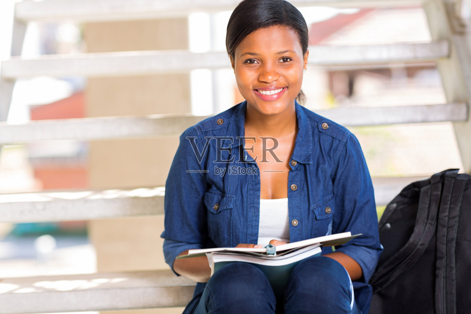 坐在台阶上的非洲女大学生照片摄影图片