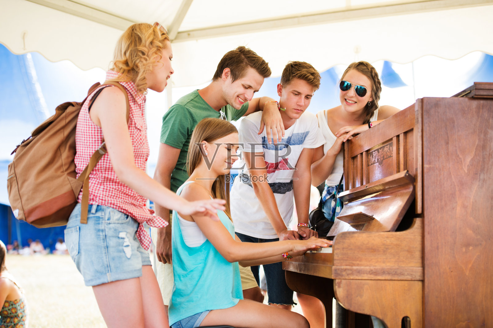 青少年在夏季音乐节上，女孩在弹钢琴照片摄影图片