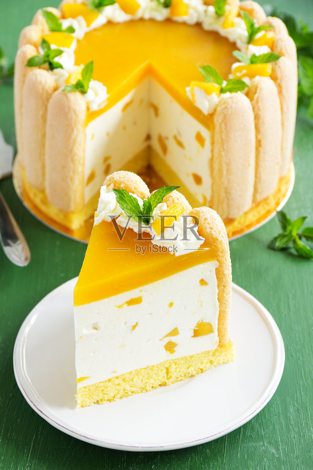 美味的磅蛋糕“夏洛特”与芒果和桃子。照片摄影图片