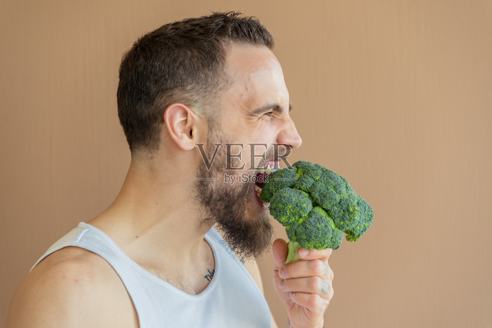 一个长胡子的家伙闻花椰菜照片摄影图片