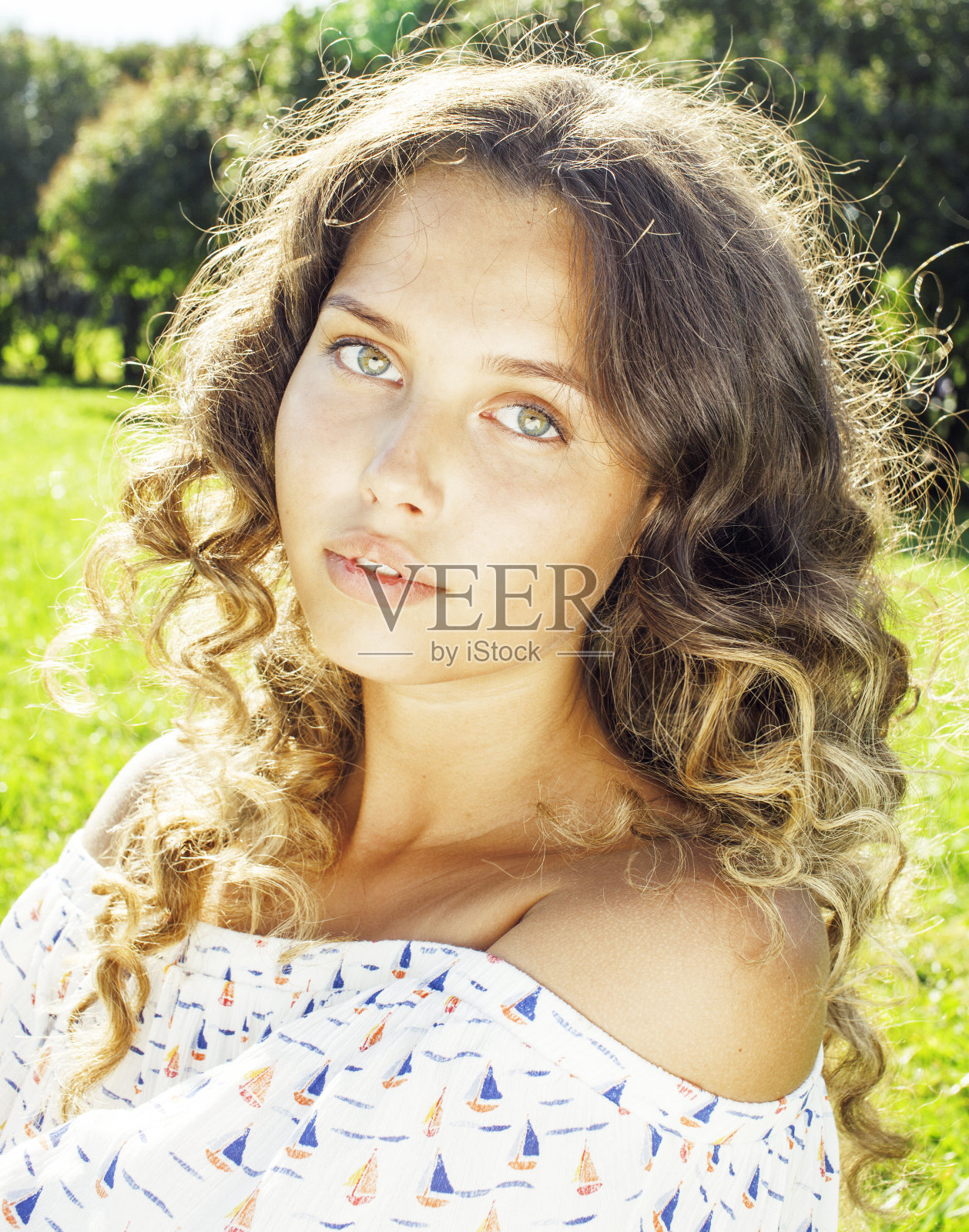 年轻可爱的夏天女孩在绿色的草地上放松微笑照片摄影图片