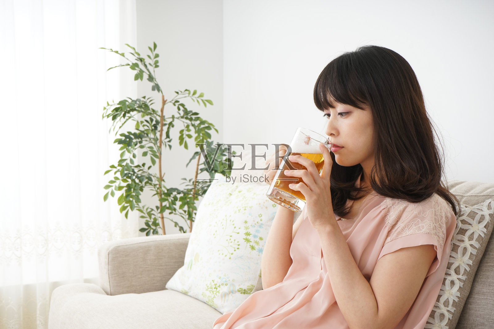 年轻女子在家里喝啤酒照片摄影图片