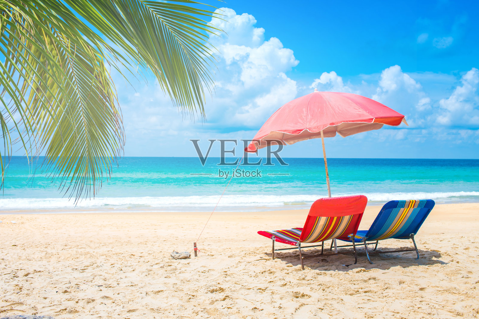 带伞的沙滩椅和夏天的沙滩。照片摄影图片