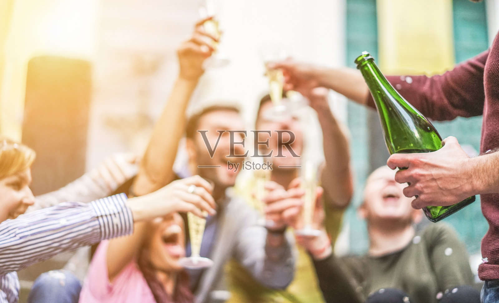 快乐的朋友庆祝喝香槟和聚会户外-年轻的学生有乐趣在日落-青年和fest概念-柔软的焦点右手与瓶子-温暖的对比过滤器照片摄影图片