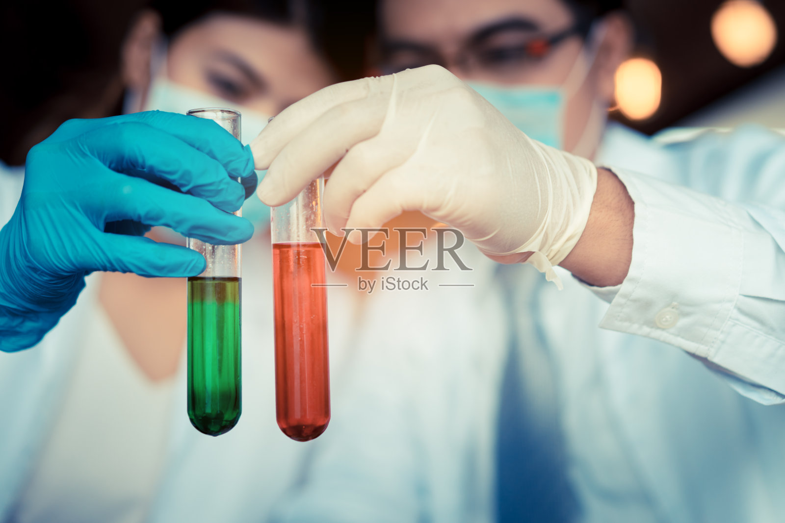 科学家男女用眼镜工作研究，并通过合成化合物在实验室配色和试管进行实验照片摄影图片
