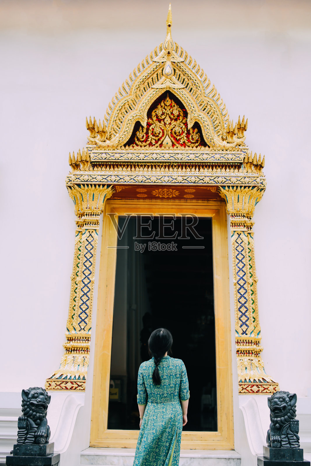 身着亚洲传统服饰的女子站在泰国曼谷的寺庙内，欣赏佛教和泰国文化照片摄影图片